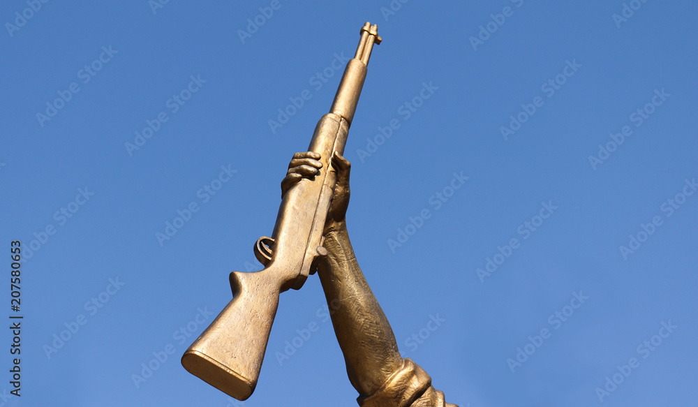 The hand of the statue with its gun.