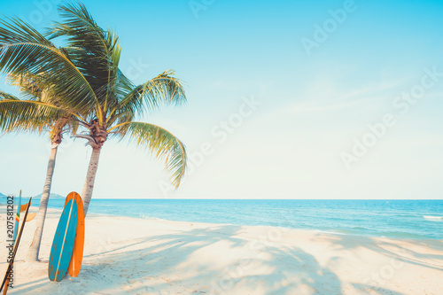 Fototapeta Naklejka Na Ścianę i Meble -  Vintage surf board with palm tree on tropical beach in summer. vintage color tone