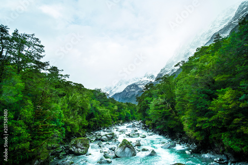 A blue glacier river among the green nature.