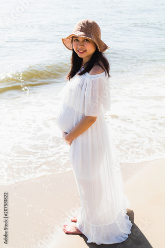 Asian pregnant women standing near the sea