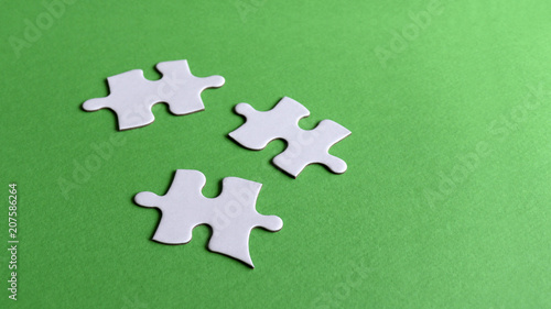Three puzzle pieces on the light green background.