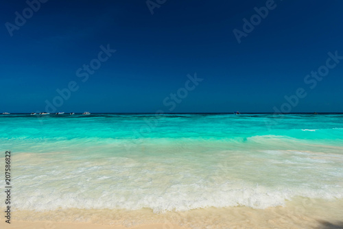 Beautiful water spalsh and bright water at the tropical beach with blue sky © peangdao