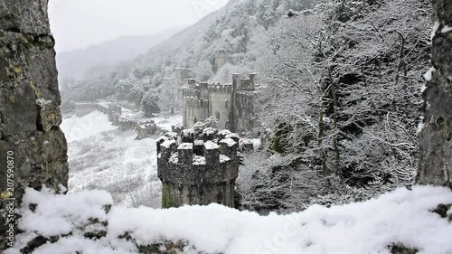 Gwrych castle Ruins framed by turret wall, British European castle Snowing gently, magical covered in snowy winter landscape