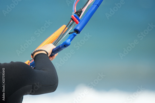 Kitesurfer ready for kitesurfing rides in blue sea detail control bar