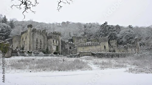 Gwrych castle Ruins in snow, British European castle Snowing gently wide establishing shot, covered in snowy winter landscape