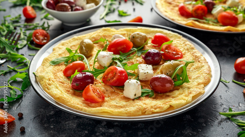 Vegetables Eggs Omelette with tomatoes, wild rocket, greek cheese, olives in a plate. Morning breakfast. healthy food