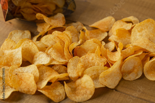 Potato chips  top view. Salty crisps scattered on a table.