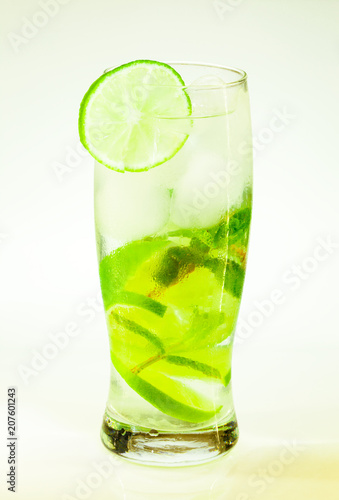 summer cold drink mojito lime and mint with ice and soda with drops on a glass on a white background
