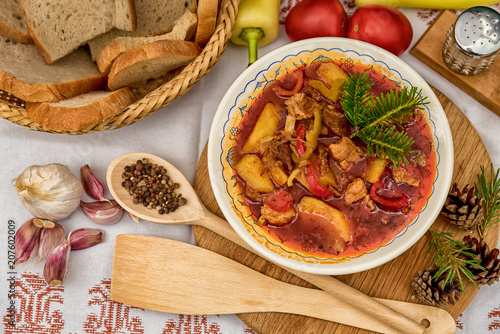 Pot goulash with divas placed on the table of ingredients - meat, pepper, tomato, spices, potatoes, garlic, onion recipe for the preparation of traditional European food