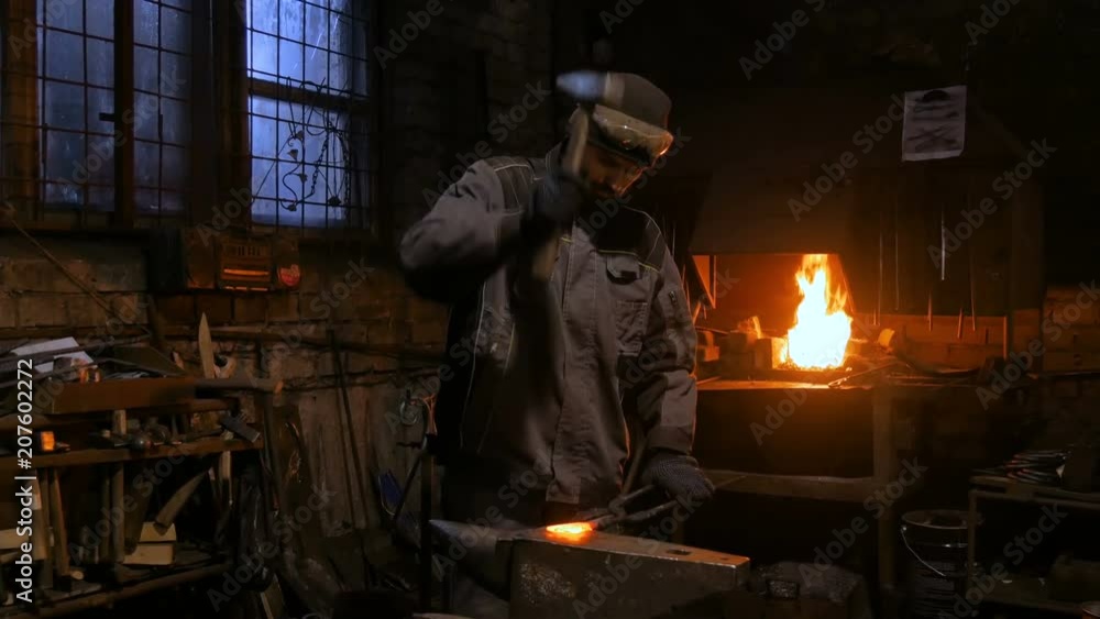 Professional blacksmith forging molten metal on anvil at smithy, workshop. Handmade, craftsmanship and blacksmithing concept Professional blacksmith forging molten metal on anvil at smithy, workshop. Handmade, craftsmanship and blacksmithing concept