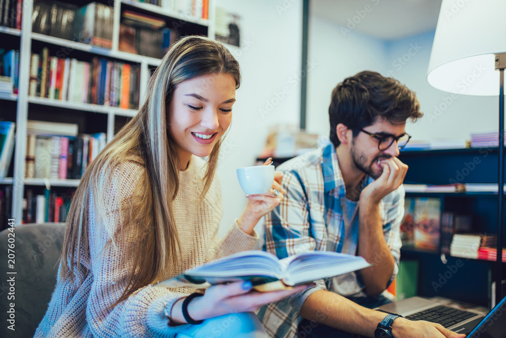 Young couple is working in cafe on laptop and smiling.
