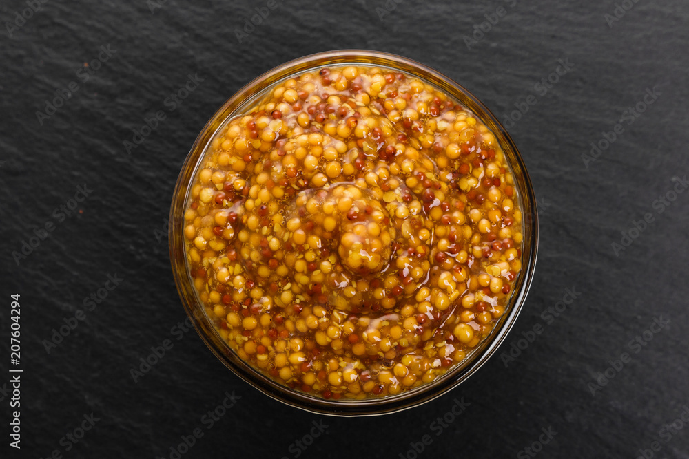 mustard in a bowl on a rustic background