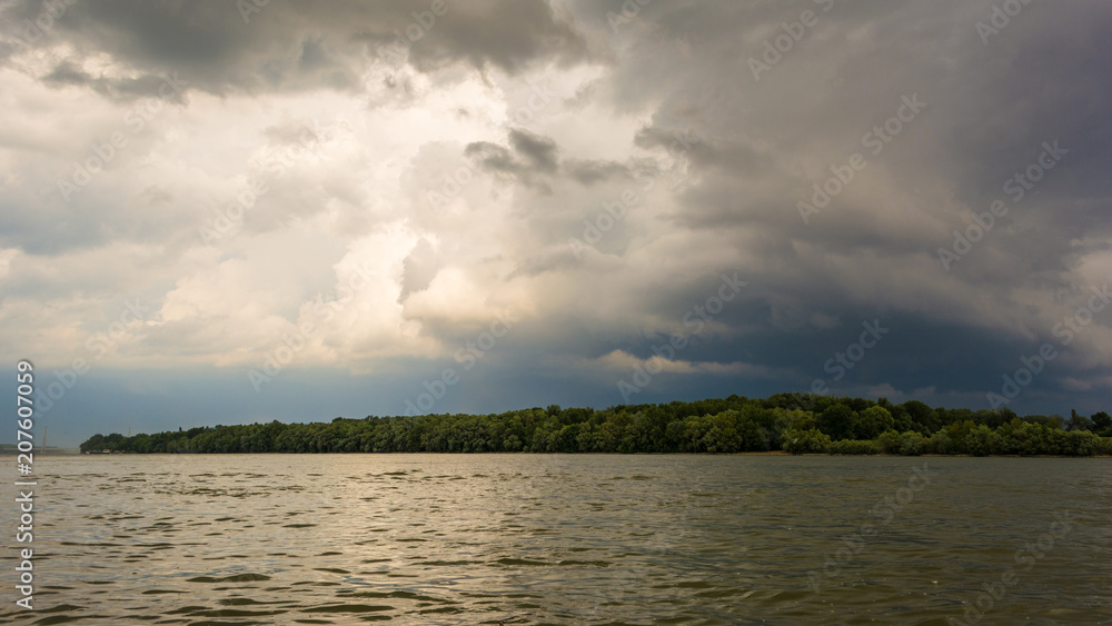 dark storm clouds with background. Dark clouds before a thunder-storm at riverside of Danube.
