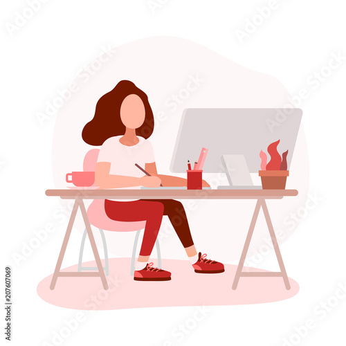 Woman graphic designer working on computer while sitting at the table indoors