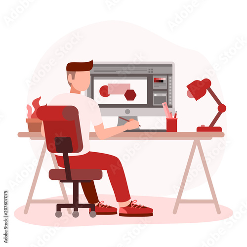 Man graphic designer working on computer while sitting at the table indoors