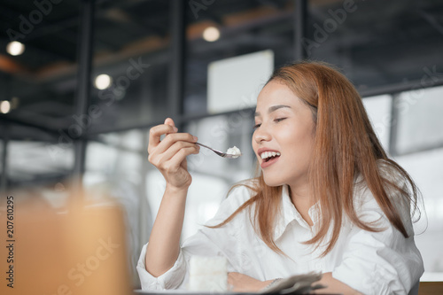 Woman eating cake at dessert cafe.