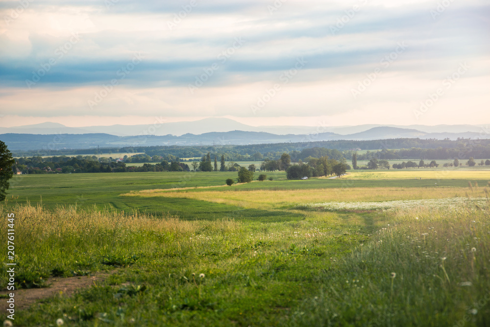Evening summer landscape with low mountains and road, Czech Republic.