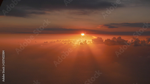 The red sunset of the sun in the sky OVER THE CLOUDS