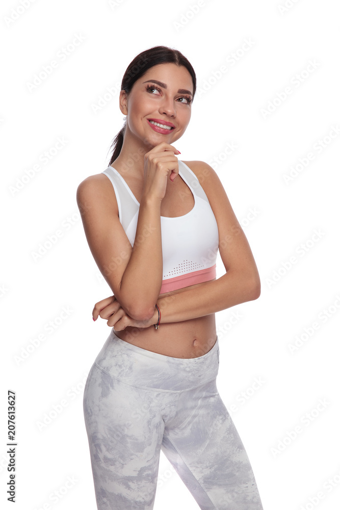 pensive fitness woman looks up to side while smiling pensive fitness woman looks up to side while smiling