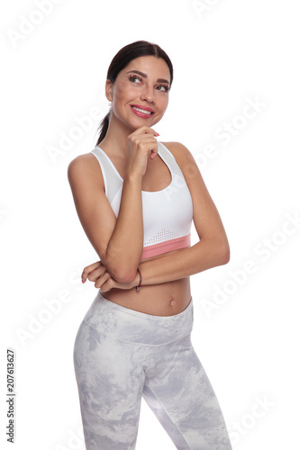 pensive fitness woman looks up to side while smiling