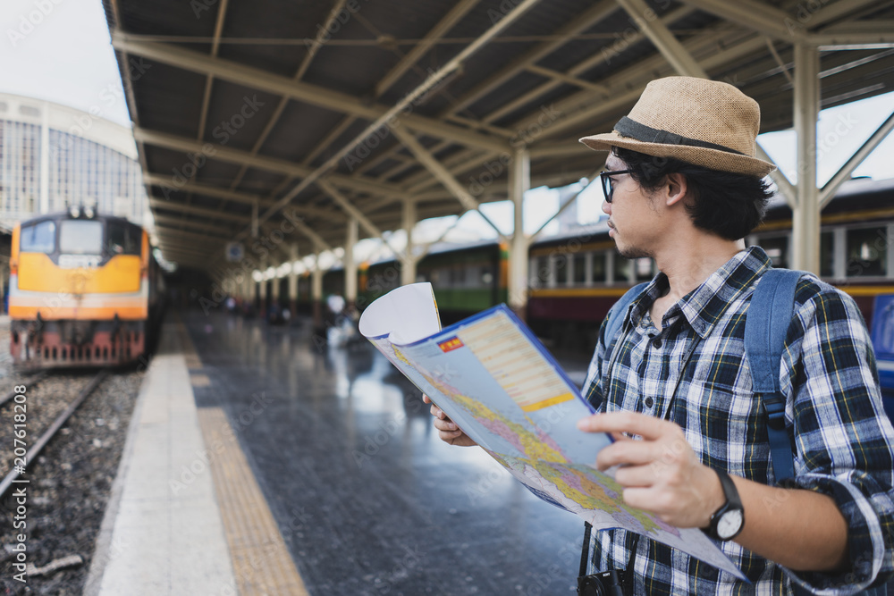 Asian man bag pack tourist with map in railway station at Thailand. Asian man bag pack tourist with map in railway station at Thailand.