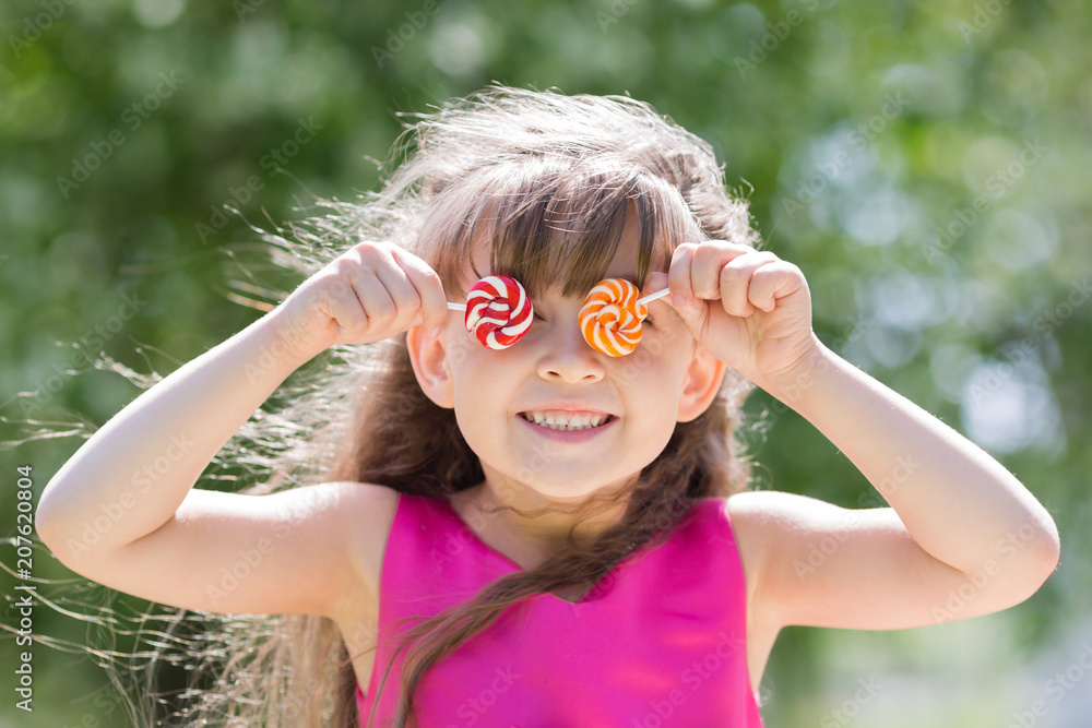 The little girl closed her eyes with sugar candies. The girl playing brought sweet sweets to her eyes and closed them. The little girl closed her eyes with sugar candies. The girl playing brought sweet sweets to her eyes and closed them.