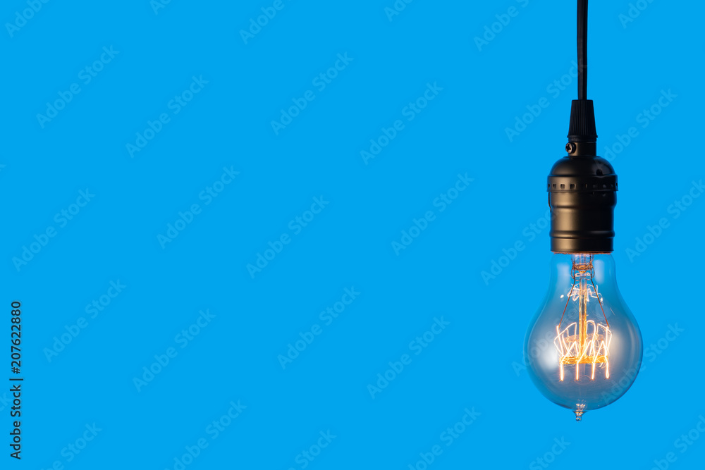 Edison light bulb on blue background. space for text Edison light bulb on blue background. space for text