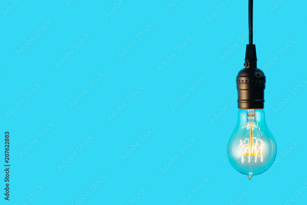Edison light bulb on blue background. space for text Edison light bulb on blue background. space for text
