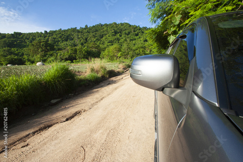 Family car on the soil road, Trip to Nature of mountain. Open turn single for safety,view on front and mirror beside car.