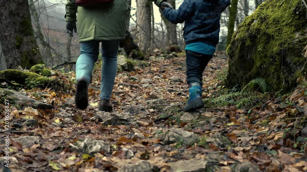 Traveling With Child - Unidentified Young Mother And Little Son Are Walking Along Stony Autumn Forest During A Tourist Trip To Nature Traveling With Child - Unidentified Young Mother And Little Son Are Walking Along Stony Autumn Forest During A Tourist Trip To Nature