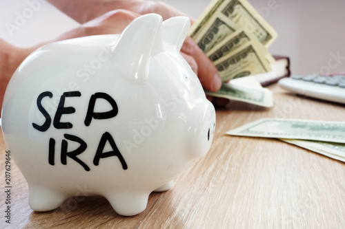 Foto SEP IRA written on a side of piggy bank. Pension plan.