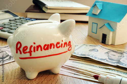 Photos Refinancing written on a piggy bank.