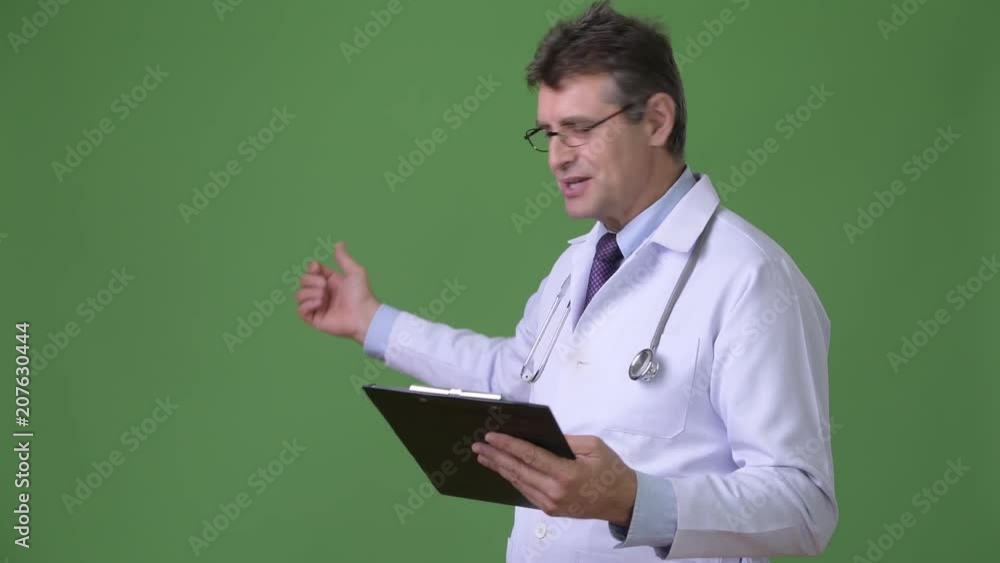 Mature handsome man doctor against green background Mature handsome man doctor against green background