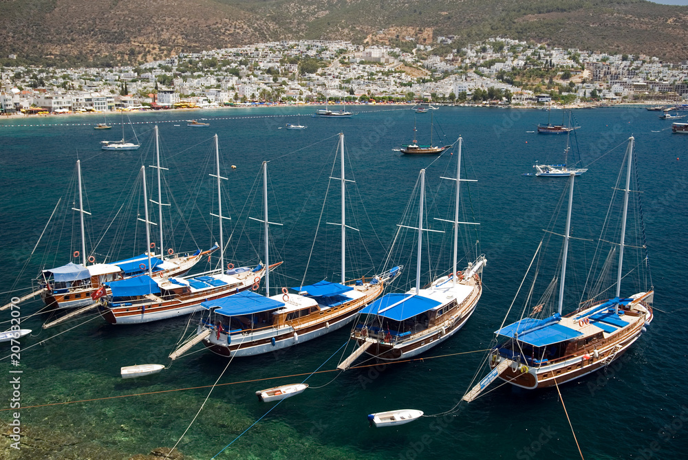 Turkish traditional wooden boats gulets anchored in front of Bodrum Castle, Turkey.