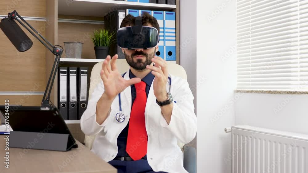 Portrait of a doctor using a VR virtual reality heandset. He is in his office and wears a white robe with formal suit and red tie. Future of the medicine. Shot on motorised slider. Dolly footage Portrait of a doctor using a VR virtual reality heandset. He is in his office and wears a white robe with formal suit and red tie. Future of the medicine. Shot on motorised slider. Dolly footage