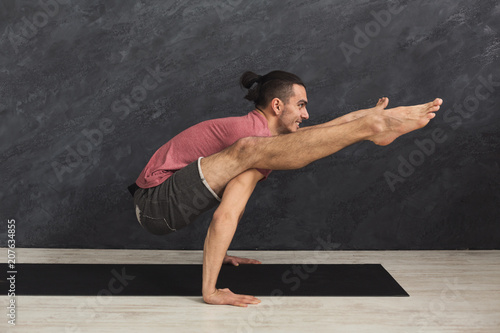 Young flexible man standing on hands © Prostock-studio