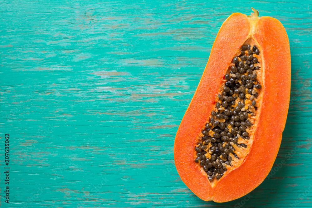 Papaya fruit on wooden background.Slices of sweet papaya on wooden background,Halved papayas with leaves, Papaya fruit on wooden background.Slices of sweet papaya on wooden background,Halved papayas with leaves,