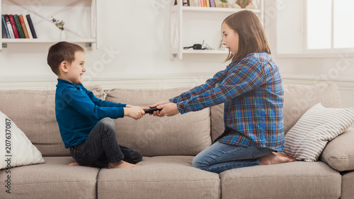 Photography Siblings fighting over remote control at home