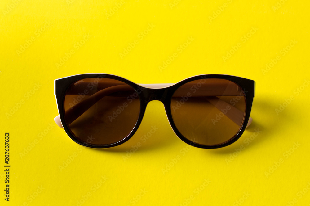Sunglasses on yellow background. The concept of summer. Empty text space Sunglasses on yellow background. The concept of summer. Empty text space