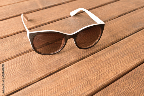 Sunglasses on a wooden table. The concept of summer. Empty text space