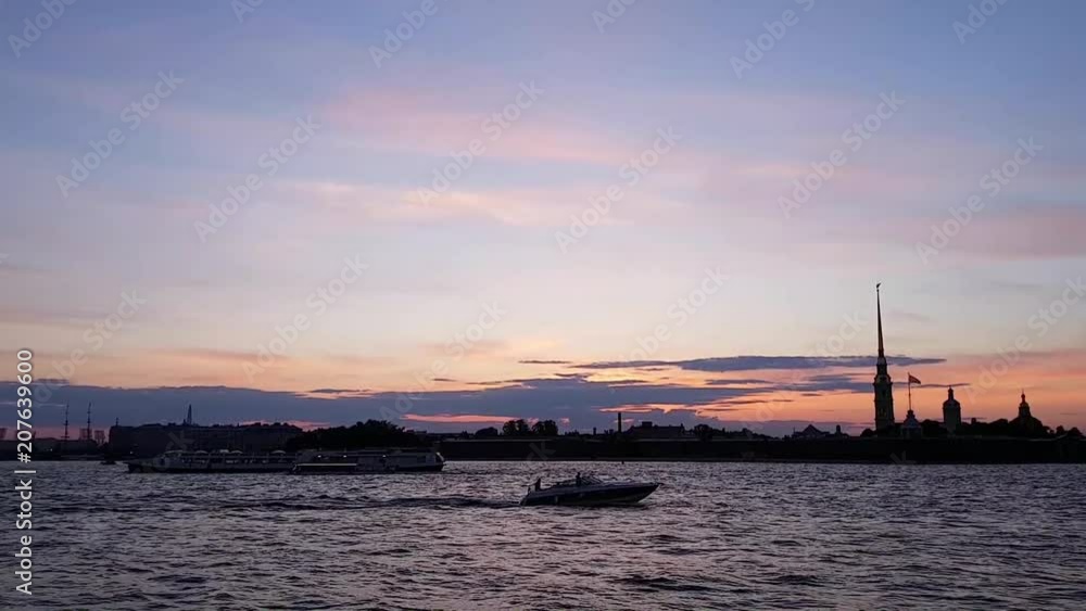 A fast boat and a ship floating on the Neva river in the white nights. Sunset in the center of St. Petersburg. Travel to Russia during the late sunsets A fast boat and a ship floating on the Neva river in the white nights. Sunset in the center of St. Petersburg. Travel to Russia during the late sunsets