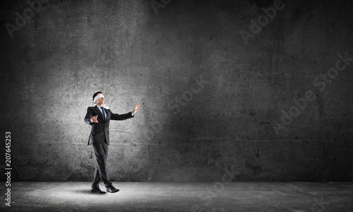 Canvas Print Business concept of risk with businessman wearing blindfold in empty concrete ro