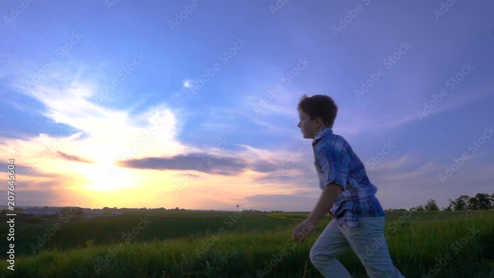 Silhouette of boy launching his airplanes against sunset Silhouette of boy launching his airplanes against sunset
