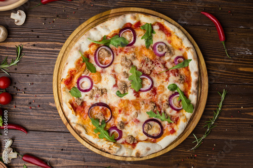 Minced meat tomato red onion pizza on a wood background