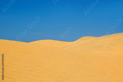 View on hills in a desert with blue sky.