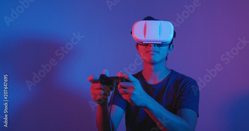 Young Man play game on VR under red and blue light