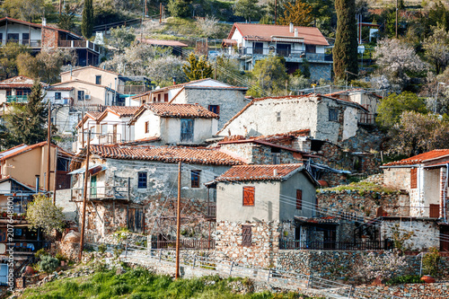 Old clay houses with tiled roofs in a small mountain village on the island of Cyprus, the traditional ancient architecture photo