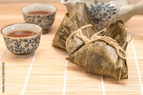 Zongzi - Traditional Dragon Boat Festival dumpling. Hand drawn watercolor painting isolated on wood background.