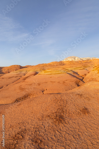 Multicolored red  orange and yellow striped hills under a bright blue sky in Eastern Kazakhstan