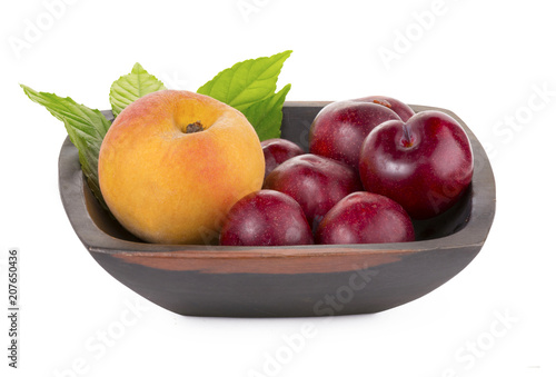 Peaches, apricots and plums in a basket isolated on white background